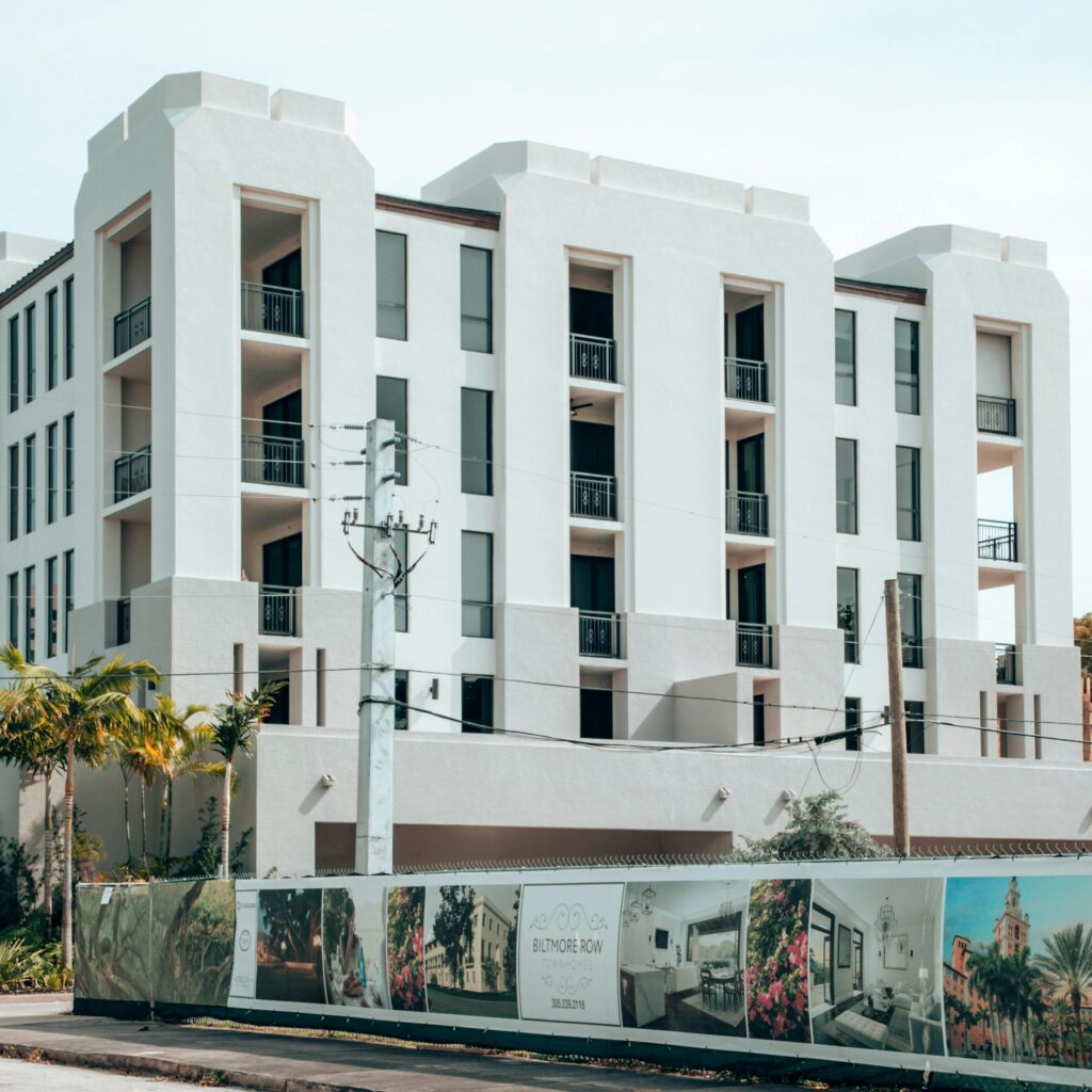 Elegant modern apartment building exterior in Coral Gables, Florida, under a clear blue sky.